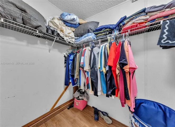 Storage area featuring wire shelving and wood-finish flooring