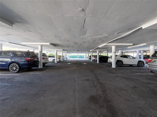 Covered parking structure featuring concrete flooring and integrated lighting