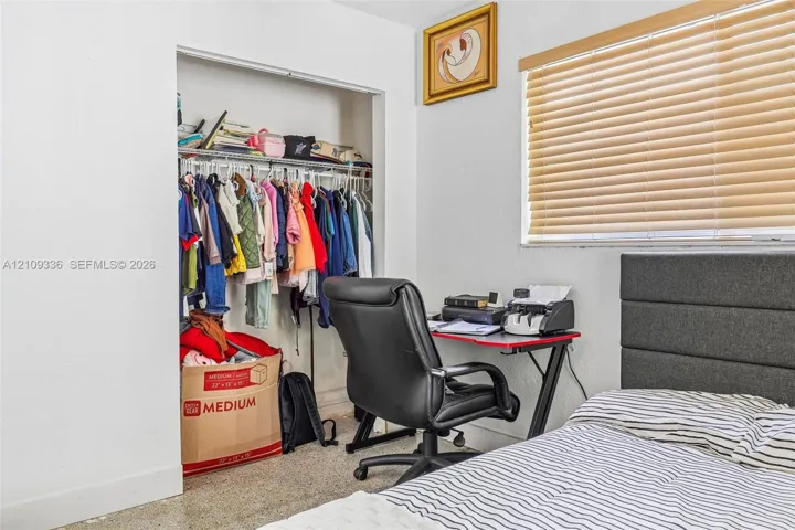 Interior space featuring a built-in reach-in closet with wire shelving and horizontal slat window blinds