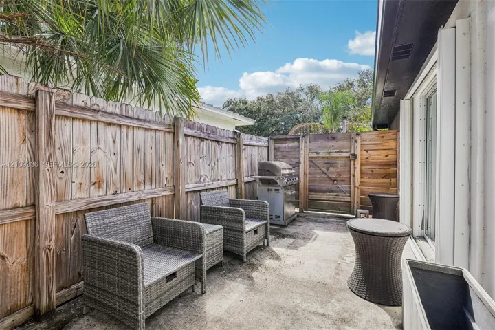 Concrete patio featuring a vertical wood-plank privacy fence and an integrated wooden access gate