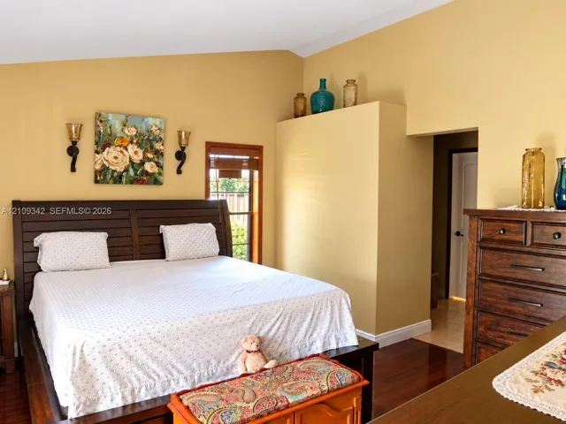 Vaulted ceilings, wood-finish flooring, and wall-mounted metal sconces
