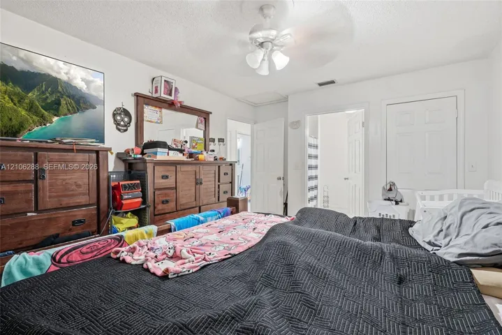 Room featuring white walls, a ceiling fan with integrated lighting, and white six-panel interior doors