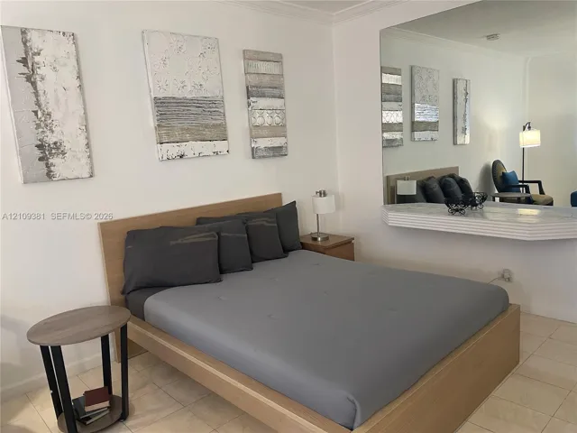 Large wall-mounted mirror featuring a wide, integrated shelf with a molded edge and tile flooring