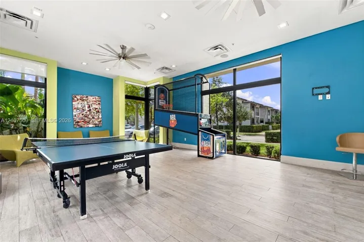 Recreation space featuring wood-finish flooring, recessed lighting, ceiling fans, and floor-to-ceiling windows
