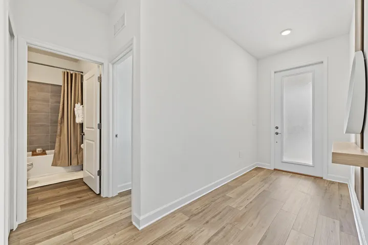 Entryway featuring vinyl wood-finish flooring, recessed lighting, and a frosted-glass panel door
