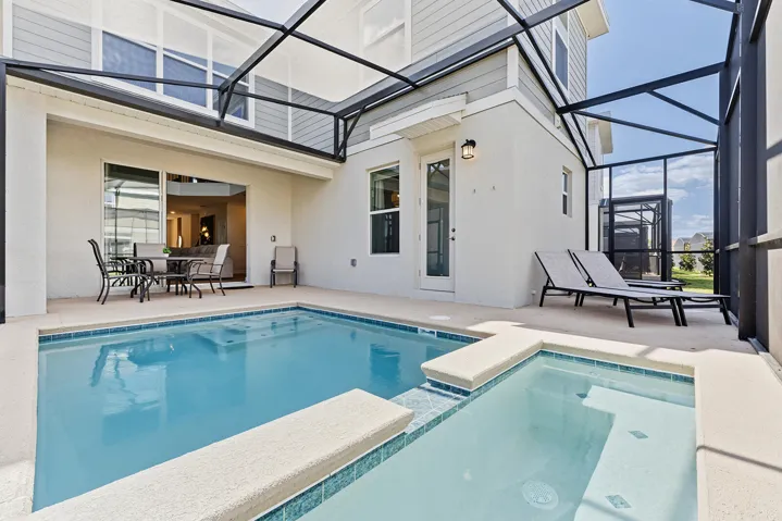 Screen-enclosed patio area featuring a concrete deck, an integrated swimming pool, and a raised spa with tiled waterline accents