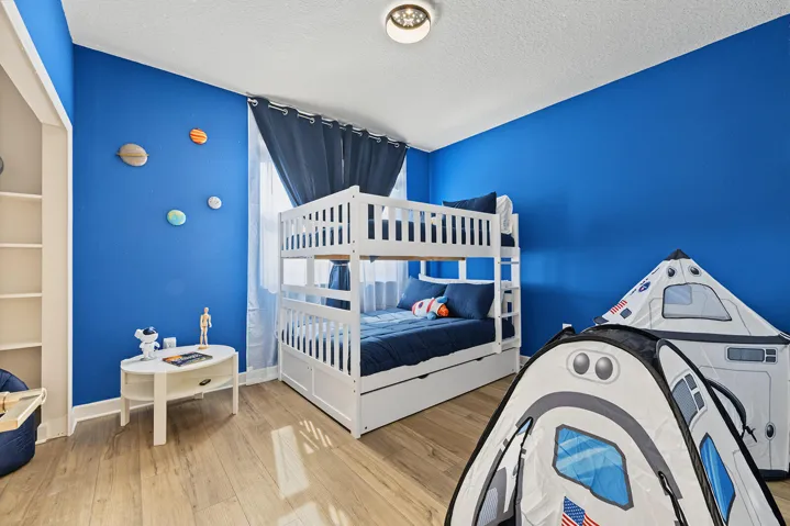 Room featuring vinyl wood-finish flooring, a built-in recessed shelving unit, and a flush-mount ceiling light fixture