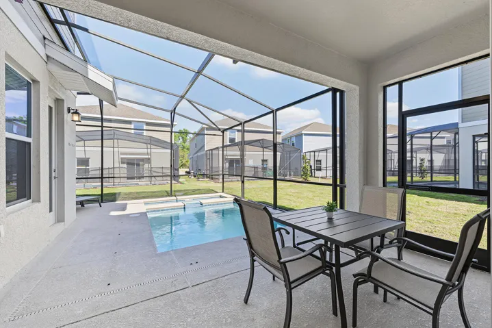Screened-in lanai featuring a concrete patio, integrated swimming pool with raised water feature, and a door for exterior access