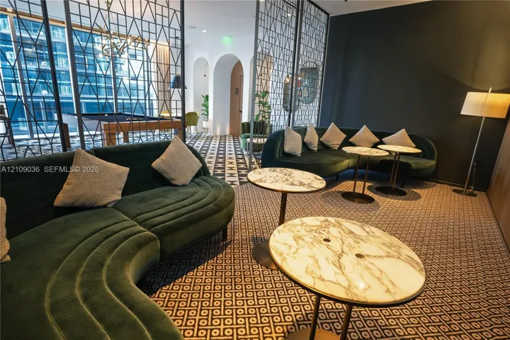 Common area featuring decorative metal room dividers, arched architectural alcoves, and patterned flooring