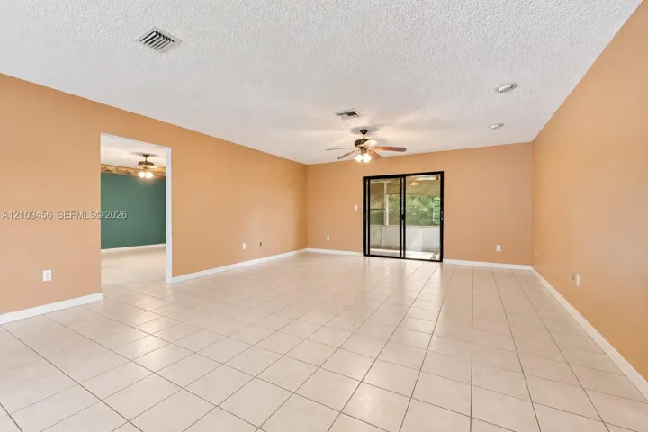 Open-concept space featuring tile flooring, recessed lighting, a ceiling fan, and sliding glass doors