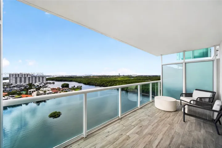 Covered balcony featuring wood-finish flooring, glass panel railings, and privacy glass partitions