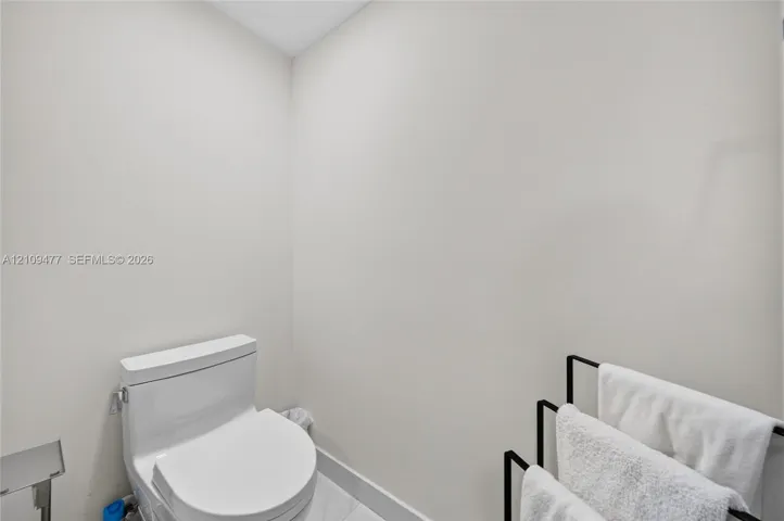 One-piece porcelain toilet with a modern silhouette and tile flooring