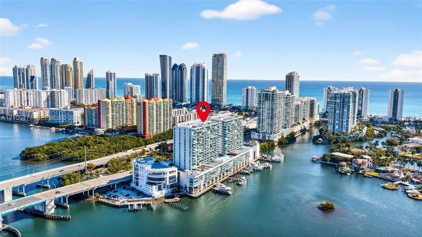 High-rise waterfront property featuring a multi-story exterior, glass balcony railings, boat slip access, and an urban coastal location