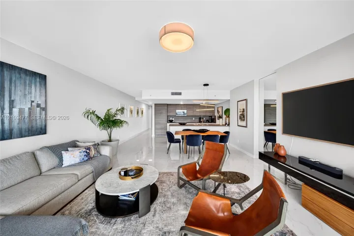 Open-concept living space featuring high-gloss tile flooring, recessed lighting, and a kitchen equipped with flat-panel cabinetry