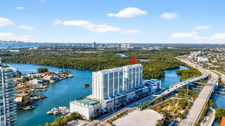High-rise building featuring a roof-level swimming pool, floor-to-ceiling glass windows, and a waterfront position