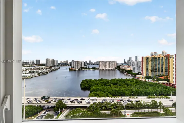 Expansive window offering a wide-angle perspective of the waterfront, urban skyline, and natural foliage