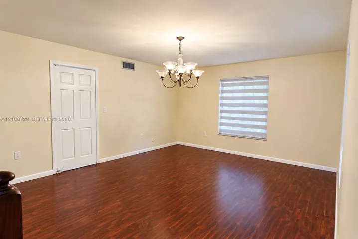 Wood laminated flooring, multi-light chandelier, interior door with access to the kitchen