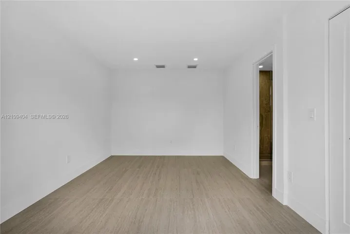 Room featuring wood-finish flooring, recessed lighting, and a neutral color palette