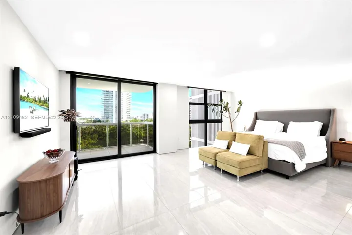 Light-filled Primary Bedroom featuring large-format polished tile flooring, floor-to-ceiling glass sliding doors, and a private balcony with a metal railing
