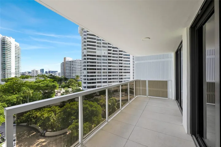 Covered balcony featuring large-format tile flooring and a glass-paneled railing