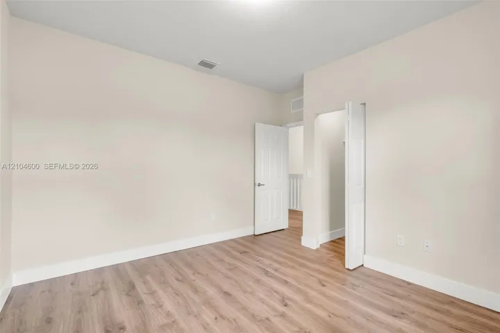 Neutral-toned interior space featuring wood-finish flooring and two six-panel doors
