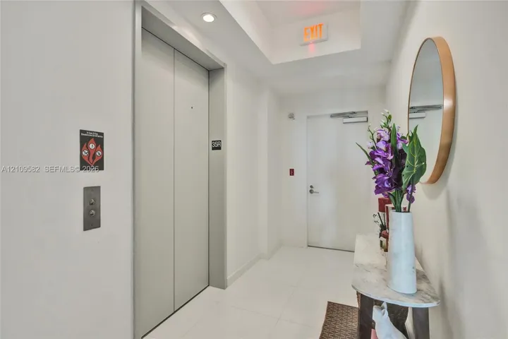 Elevator, foyer, featuring metallic doors, recessed lighting, and white tile flooring