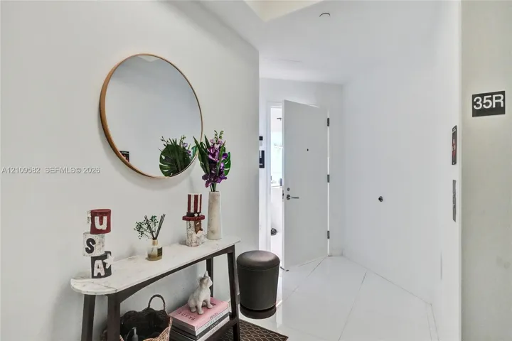 Entryway featuring white tile flooring, recessed ceiling lighting, and a neutral color palette