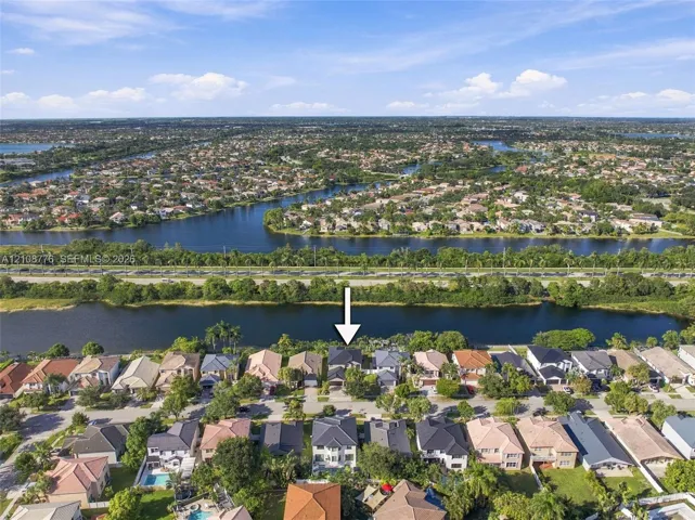 Waterfront residential property featuring a multi-story layout, shingle roof, and direct access to a canal waterway