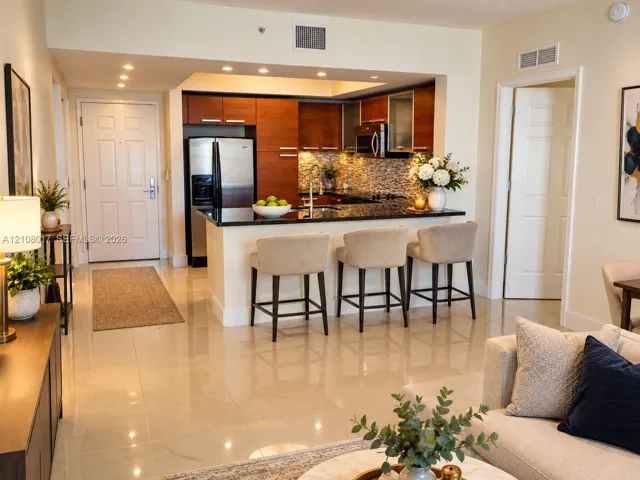 Kitchen featuring dark wood-finish cabinetry, stone countertops, stainless steel appliances, a tile backsplash, and recessed lighting