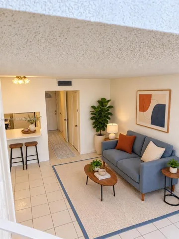 Open-concept floor plan featuring ceramic tile flooring, a breakfast bar with built-in counter space, and a flush-mount ceiling light fixture