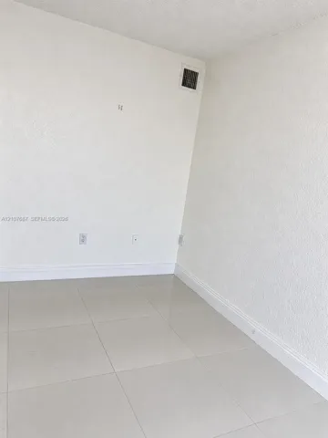 Interior space featuring neutral wall textures and large-format tile flooring