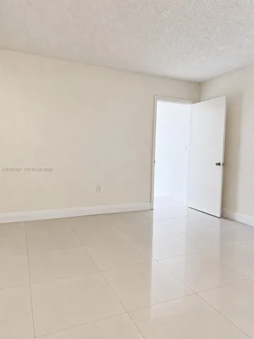 Neutral-toned interior space featuring polished large-format tile flooring and smooth-finish walls
