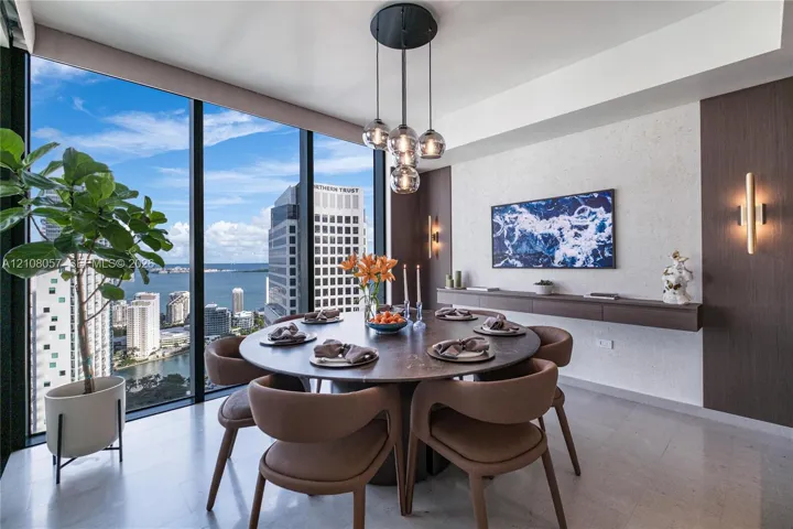 Floor-to-ceiling windows, stone flooring, custom-built wall-mounted console, multi-globe pendant lighting, and vertical wall-mounted accent fixtures