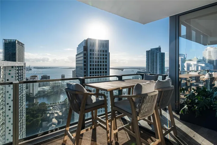Private balcony featuring a glass-panel railing, tile flooring, and floor-to-ceiling glass wall