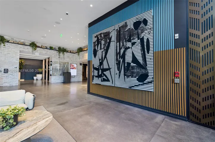 Lobby featuring polished concrete flooring, stacked stone wall accents, and vertical slatted wood wall paneling