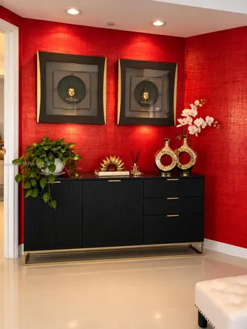 Textured red wall covering with recessed ceiling lighting and polished neutral flooring