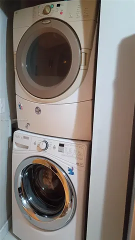 Stacked Whirlpool front-load washer and dryer unit housed in a dedicated closet