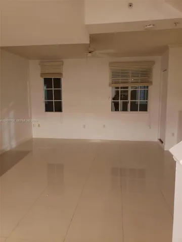 Large-format tile flooring, multi-pane windows, and a ceiling fan