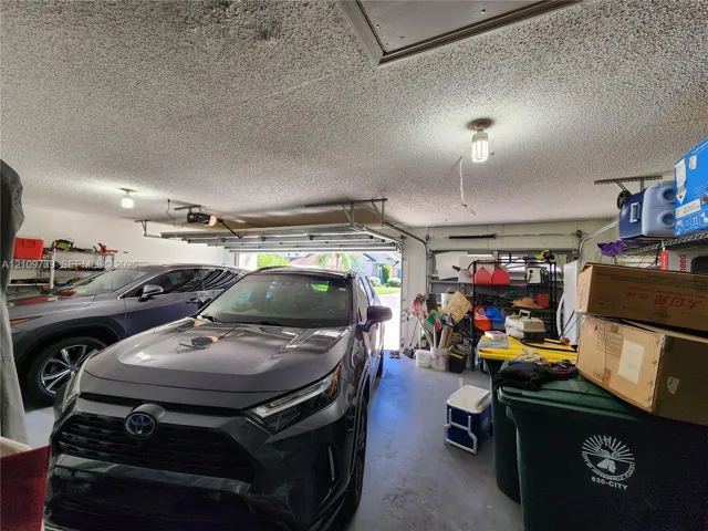 Two-car garage featuring a concrete floor, automated overhead door, and ceiling-mounted lighting