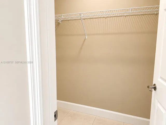 Storage space featuring tile flooring and a white wire shelf
