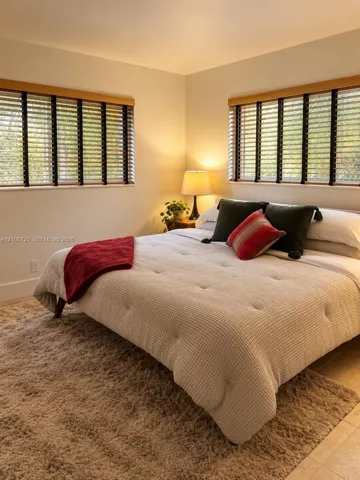 Neutral wall tones complemented by dual windows featuring wood-finish trim and horizontal window blinds