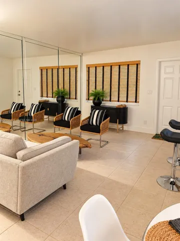 Interior space featuring expansive wall-to-wall mirror panels, large-format tile flooring, and integrated window blinds with textured fabric detail