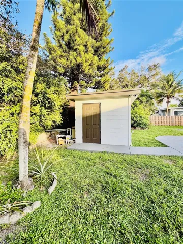 Detached storage structure featuring a concrete block exterior, a single entry door, and a concrete pad foundation
