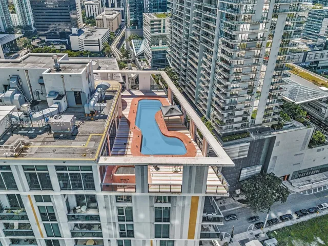 Rooftop terrace featuring an in-ground pool, elevated sun deck, and integrated shaded structure