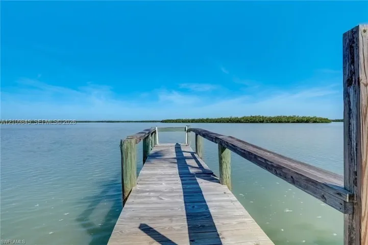 Wooden dock with timber framing and railings extending over the water
