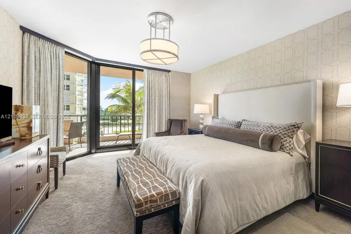 Floor-to-ceiling sliding glass doors, private balcony, patterned wall covering, carpeted flooring, and circular pendant lighting
