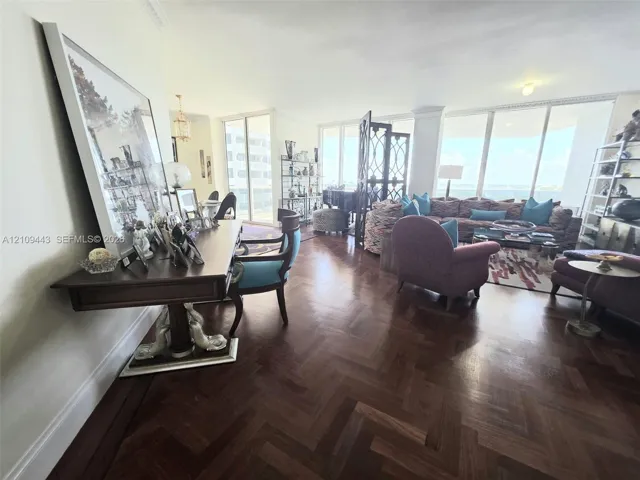 Herringbone-patterned wood-finish flooring, floor-to-ceiling windows, and crown molding