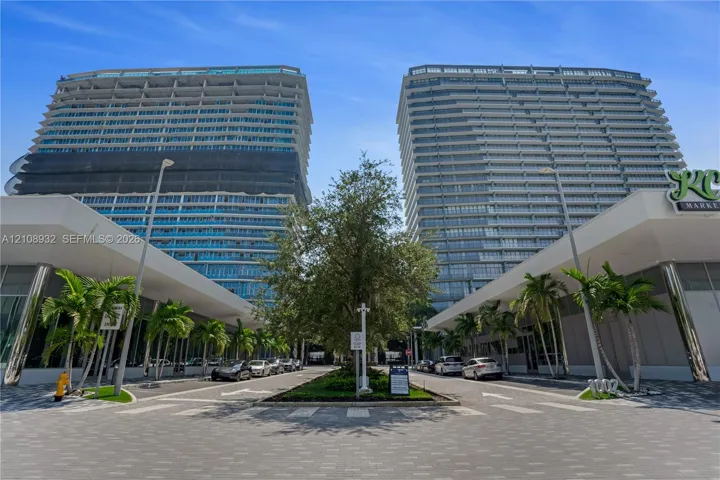 High-rise residential towers featuring glass-curtain facades, expansive balconies, integrated ground-level retail, and professionally landscaped paved entryways