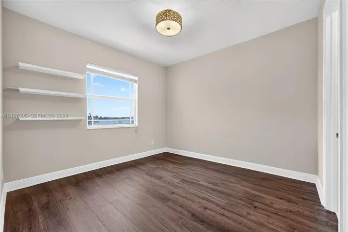 Wood-finish flooring, neutral wall tones, built-in shelving, energy-efficient window, and decorative semi-flush mount lighting