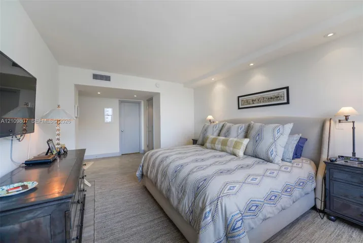 Neutral interior space featuring recessed ceiling lighting and wood-finish flooring